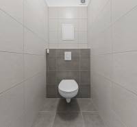 WC csempékkel a kétszobás lakásban, egyszerű dizájn és semleges színek.