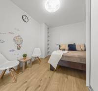 Hálószoba egy 2 szobás lakásban faldekorációval és fa dekorációjú padlóval.