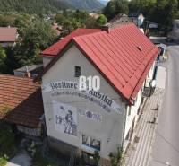 Fogadó épülete Bélán piros tetővel és falfestménnyel.