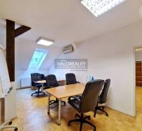 Irodák fa mintázatú padlóval és bútorokkal egy otthonos térben.