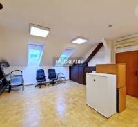 Irodák fa dekor padlóval, székekkel és ablakokkal a tetőtéri helyiségben.