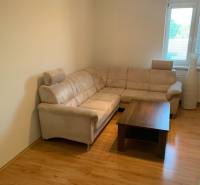 Nappali kényelmes kanapéval és dohányzóasztallal, fa dekorációjú padlón.