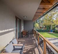 Erkély egy kétszobás lakásban Tátralomnicon, fa dekorációjú padlóval és kerti bútorokkal.