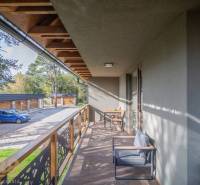 Tatranská Lomnica 2 szobás lakásának erkélye fa dekorációval és kültéri ülőgarnitúrával.