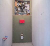 Sanitáris berendezés telepítése egy kétszobás lakásban, fa dekor padlóval.