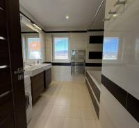 Fürdőszoba egy négy szobás lakásban káddal, mosdókkal és mosógéppel.