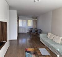 Nappali egy 4 szobás lakásban fa dekoros padlóval és étkezőasztallal.