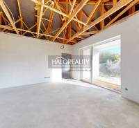 Családi ház belső tere feltárt mennyezettel és nagy üvegezett ajtókkal.