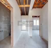 Családi ház belső tere, kilátással az átjáró folyosókra és a látható tetőszerkezetre.