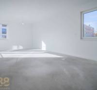 Üres szoba egy háromszobás lakásban világos falakkal és nagy ablakokkal, fa dekorációval ellátott padló nélkül.