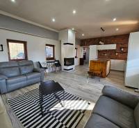 Családi ház nappalija fa dekorációjú padlóval és kandallóval.