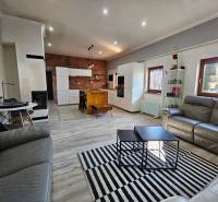 Nappali konyhával családi házban, fa dekoros padló, téglafal.