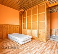 Családi ház belső tere fa dekor padlóval, matraccal és beépített szekrénnyel.