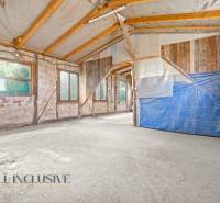 Családi ház belső tere nyers falakkal és fa gerendákkal.