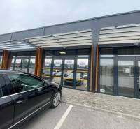 Kereskedelmi helyiségek a Brnianska utcában, Trencsénben, üveg homlokzattal és parkolóval.