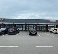 Kereskedelmi helyiségek a Brnianska utcán, Trencsénben, üzletek előtti parkolóval.