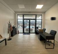 Kereskedelmi helyiségek belső tere bútorokkal és fa dekorációjú padlóval.