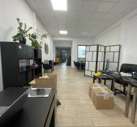 Üzlethelyiség polcokkal, asztalokkal, székekkel és fa dekorációjú padlóval.