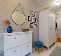 Folyosó a családi házban tükörrel, dekorációkkal és tárolóhellyel.