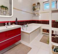 Fürdőszoba családi házban káddal, mosdóval és tároló kosarakkal.