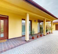 Családi ház Iža-ban, a Ďatelinová utcában, garázzsal és árkádokkal, zölddel körülvéve.