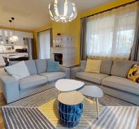 Nappali egy családi házban, fa dekoros padlóval, kanapékkal és háttérben a konyhával.