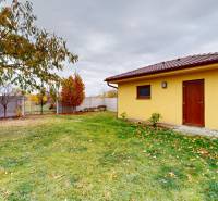 Családi ház kertje az Iž-i Ďatelinová utcában, udvaron fa pavilonnal.