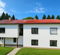 Családi ház Hájikon, Besztercebányán, piros árnyalatú tetővel és ablakokkal.