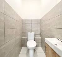 Mosdó szürke csempével és mosdókagylóval az irodák belső terében.