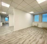 Irodák fehér mennyezettel és fa dekorációjú padlóval, két nagy ablakkal.