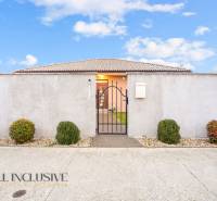 Családi ház Gabčíkovo-ban kerítéssel, kapuval és díszcserjékkel.