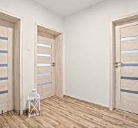 Családi ház belső tere fa dekorációjú padlóval és fehér ajtókkal.