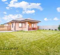 Családi ház Nagymagyaron nagy kerttel, gyepfelülettel és kerítéssel.