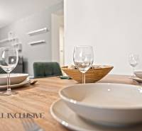 Étkezőasztal poharakkal, tányérokkal és tálkával egy családi ház belső terében.