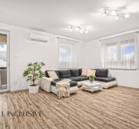 Nappali egy családi házban sarokkanapéval és fa dekor padlóval.