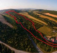 Légi felvétel a Rokycany melletti mezőgazdasági és erdős területekről, amelyeket zöldterület és út vesz körül.