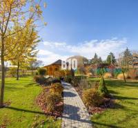 Kert a Bílkova Humencében pavilonnal és színes levelekkel díszített fákkal a családi házban.