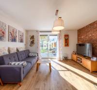 Nappali családi házban kanapéval, téglafallal és fa dekorációjú padlóval.