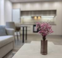 Nappali konyhával és virágokkal az asztalon egy kétszobás lakásban.