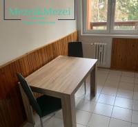 Étkező sarok egy kétszobás lakásban, fa dekorációval a falakon és csempével.