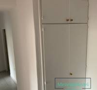 Fehér beépített tároló és csempe egy kétszobás lakásban.