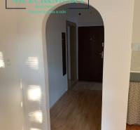 2 szobás lakás belső tere fa dekor padlóval és boltíves bejárattal.