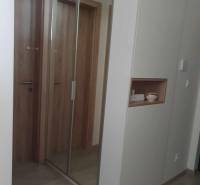 Folyosó nagy tükörrel és fa dekorációjú padlóval egy kétszobás lakásban.