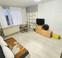 Hangulatos nappali egy kétszobás lakásban, fa dekorációjú padlóval és bútorokkal.