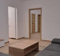 Nappali egy kétszobás lakásban kanapéval és fa dekor padlóval.