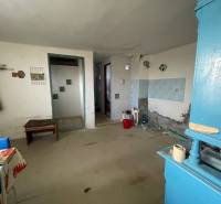 Egy családi ház belső tere egyszerű bútorokkal és kék szekrénnyel.