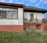 Családi ház a Fő utcán, Felsőremetén, téglából készült lábazattal és elhanyagolt kerttel.