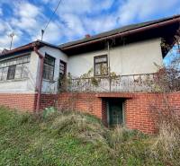 Családi ház a Fő utcán Felsőremetén régebbi homlokzattal és téglaburkolatú lábazattal.