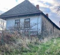 Családi ház a Fő utcán Felsőremetén, elhanyagolt kerttel és régi falakkal körülvéve.