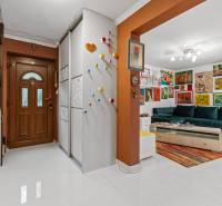 Egy családi ház folyosója színes díszítéssel és színes nappalival.